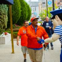 Louie the laker shaking hands with a tigers fan as they walk to the game
